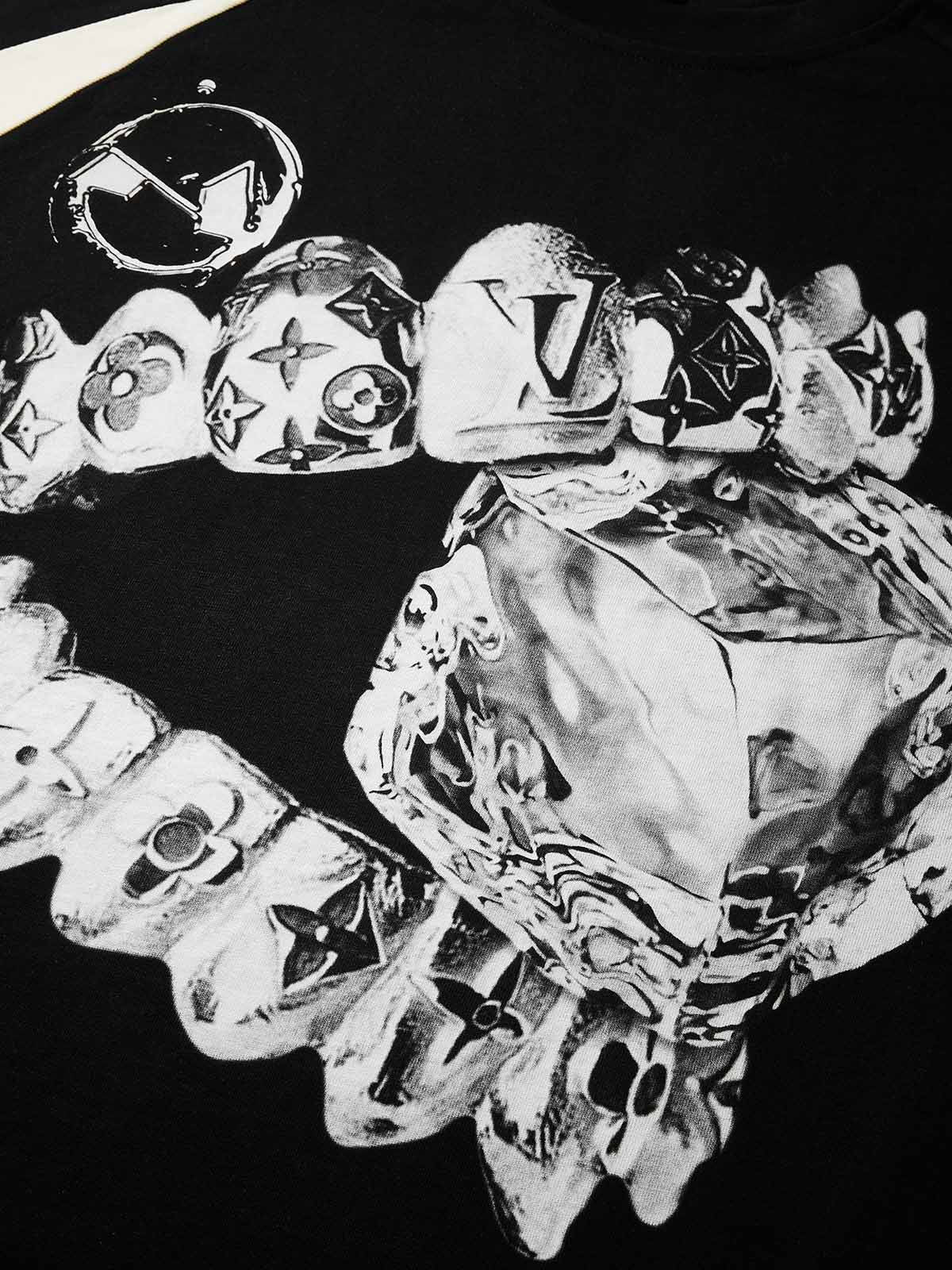 Close-up of chrome liquid metal grillz biting a diamond ice cube print on black fabric