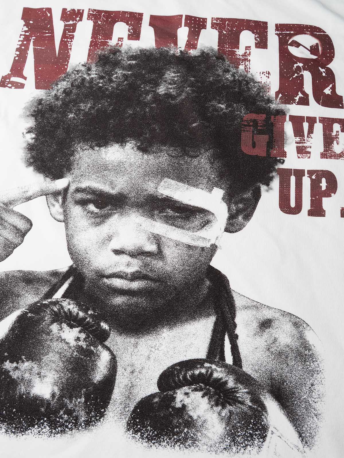 Close-up of graphic print showing a boy with boxing gloves and bandaged head