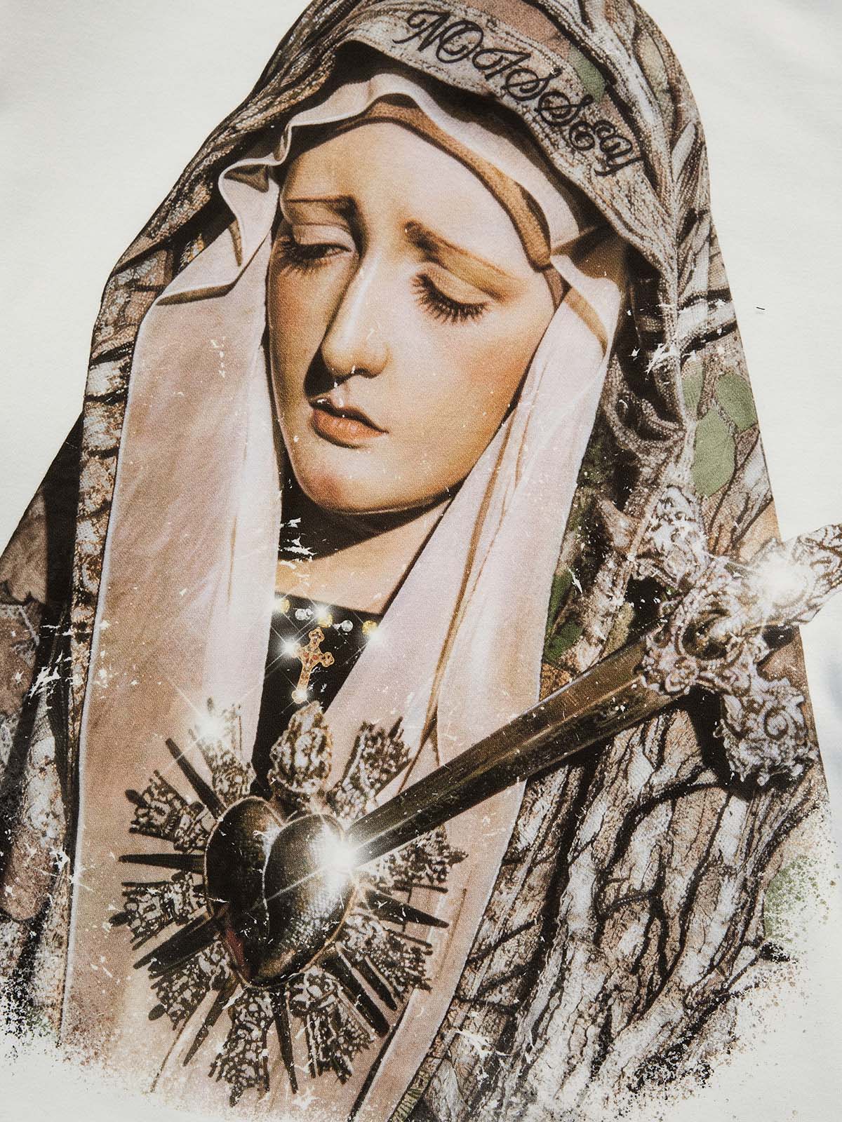 Close-up of high-definition Madonna graphic print with sacred heart and metallic accents on white fabric.