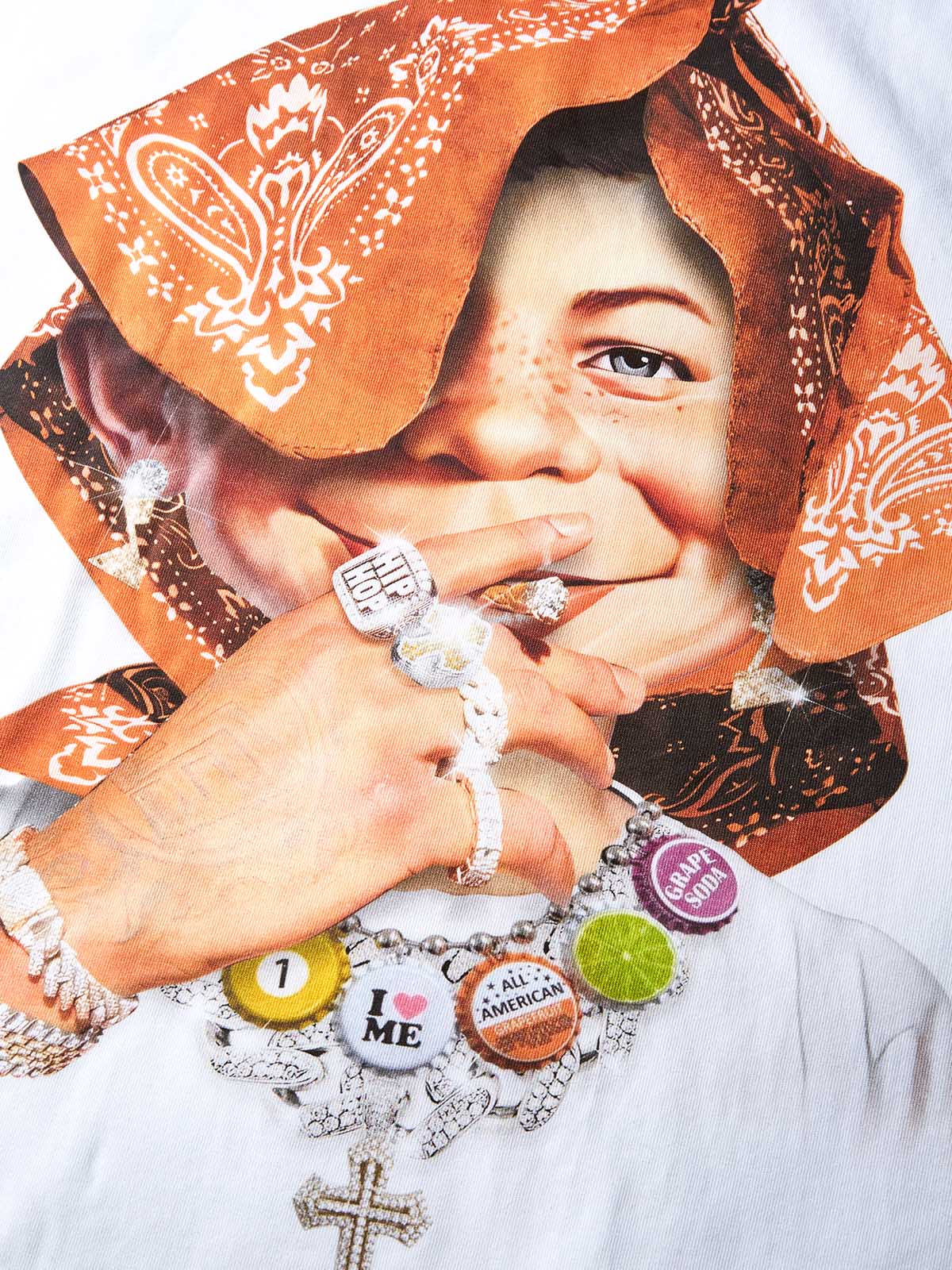 Close-up of mischievous smiling boy wearing orange paisley headscarf and I Love NY pin