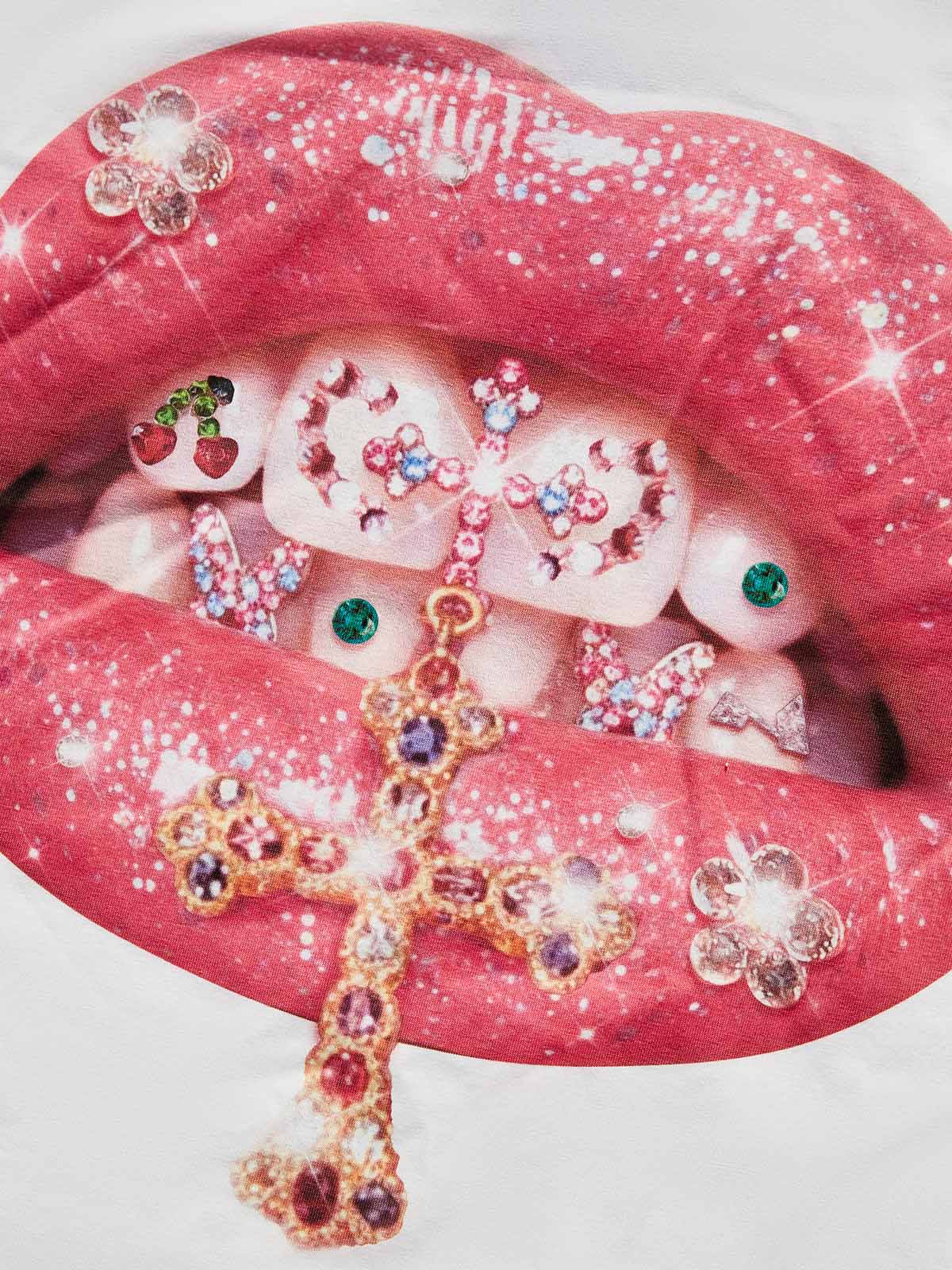 Close-up of the NOISSEY "Holy Shine" print, highlighting the jeweled cross, cherry details, and sparkling lip gloss.