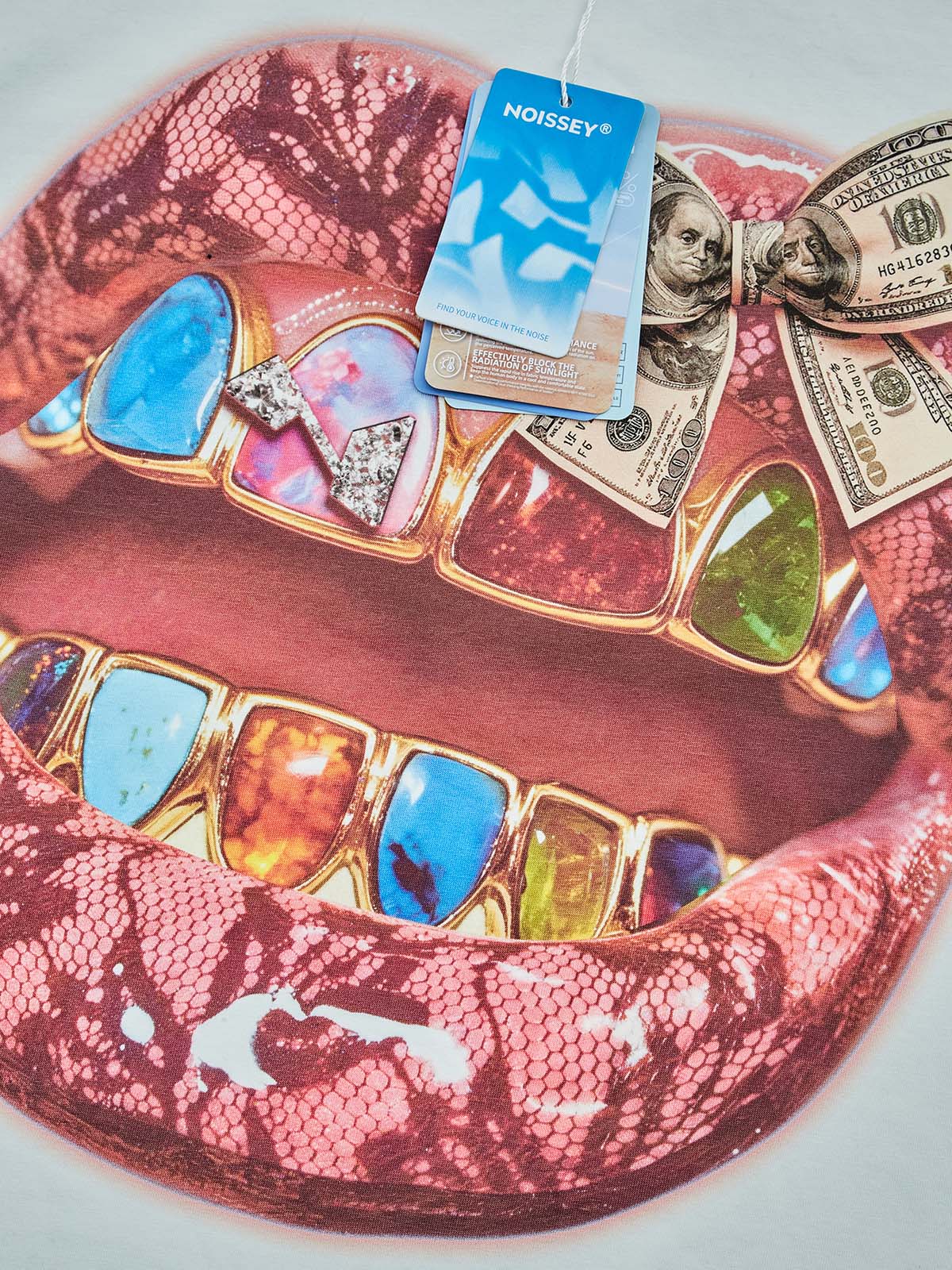 Close-up of the banknote-inspired bow and the intricate diamond-encrusted grillz on the lip graphic.