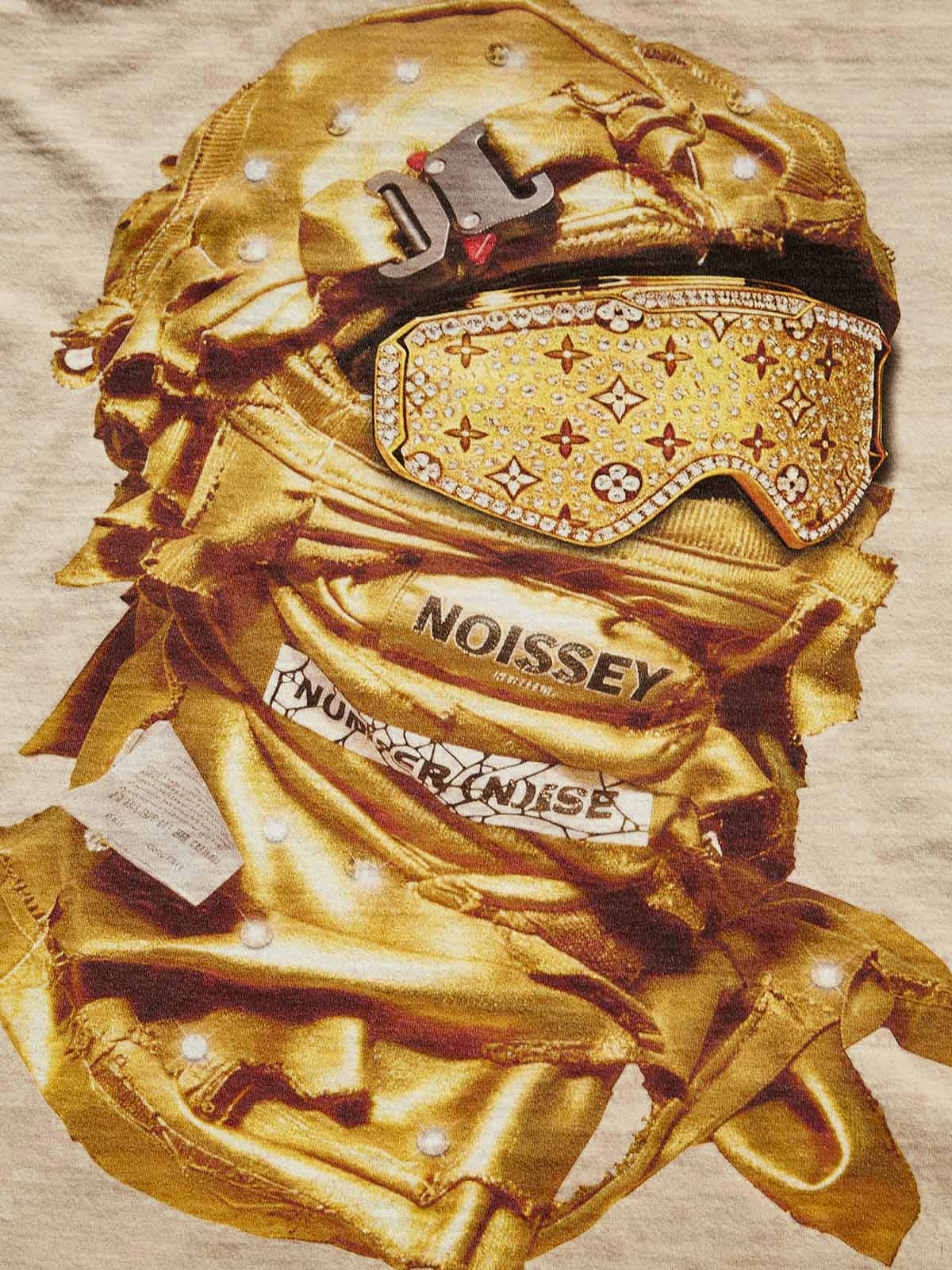 Close-up of the diamond-studded print on the Golden Balaclava Tee, highlighting the light-reflecting crystals and metallic fabric texture.