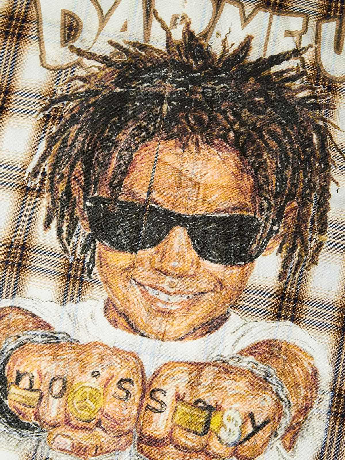 Close-up of the knuckle tattoos and the "God Bless You" badge graphic, showcasing the high-definition ink saturation and illustrative depth.