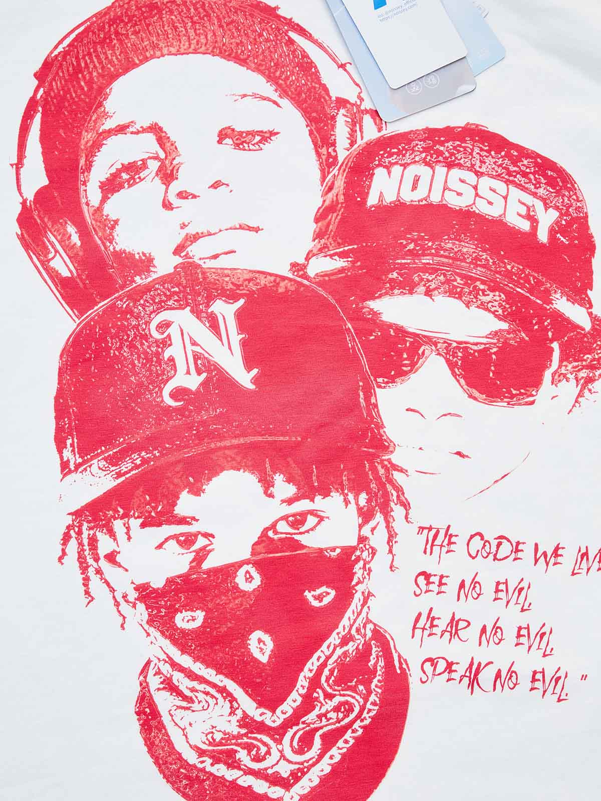 Close-up of the red child-art print featuring the text "The Code We Live By: See No Evil, Hear No Evil, Speak No Evil" in a distressed font.