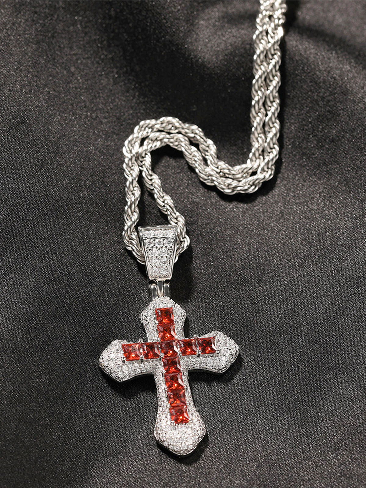 Close-up of the silver iced-out cross chain accessory styled with the red hoodie