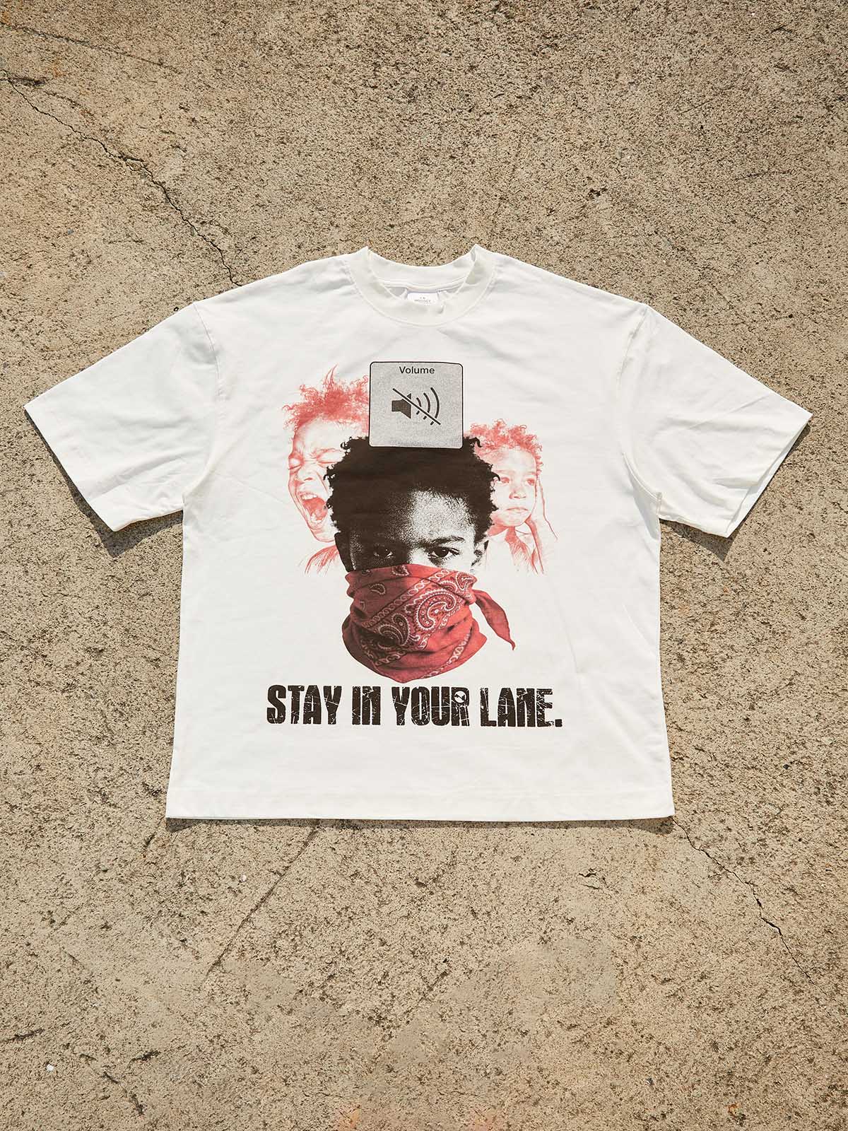Flat lay of premium cotton white t-shirt with avant-garde 'Stay In Your Lane' street art print.
