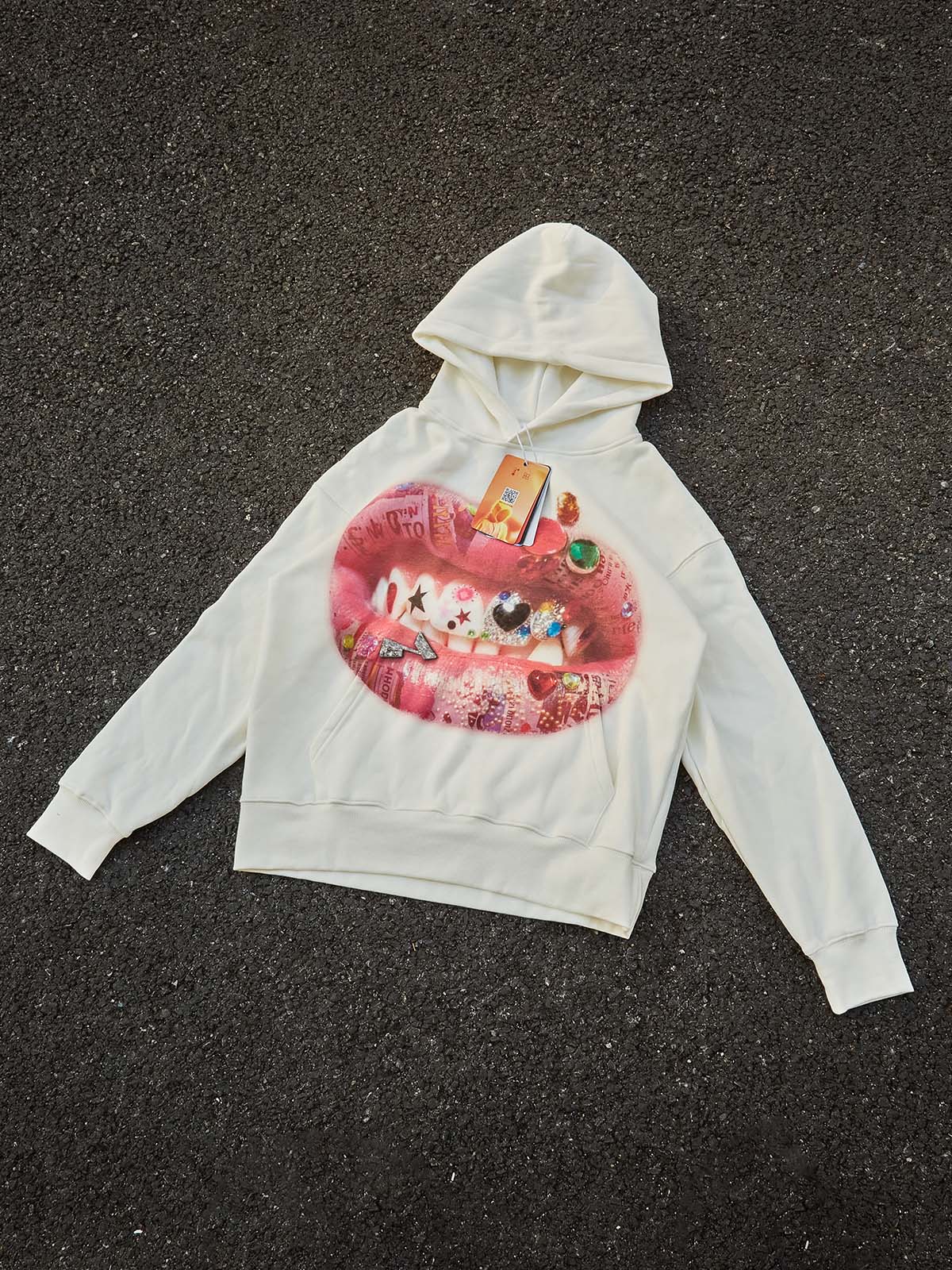 Flat lay of the DIY lip print hoodie showing the rhinestone accessories.