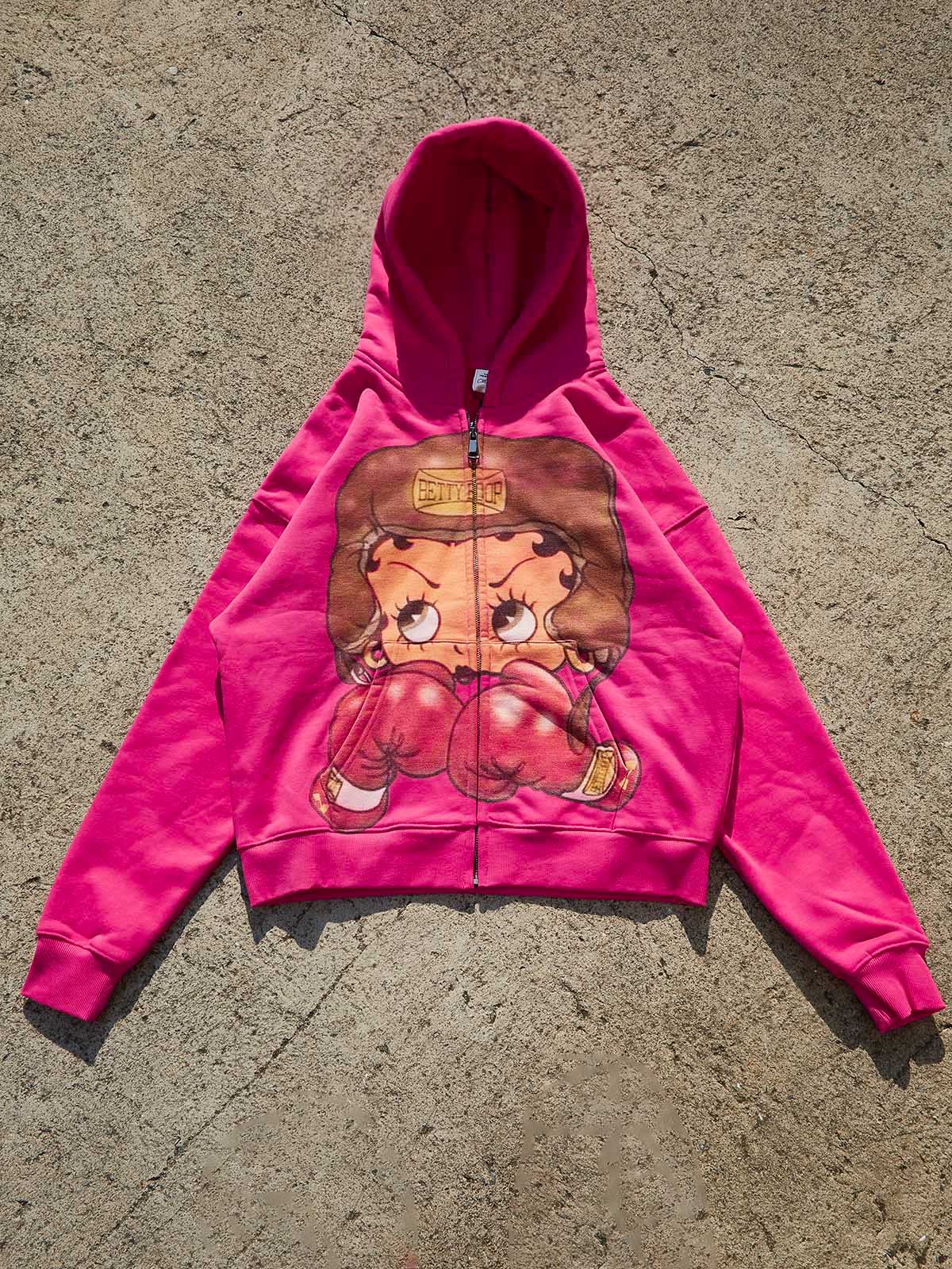 Flat lay of the cartoon boxing print hoodie showing the wide body and shorter boxy length silhouette.