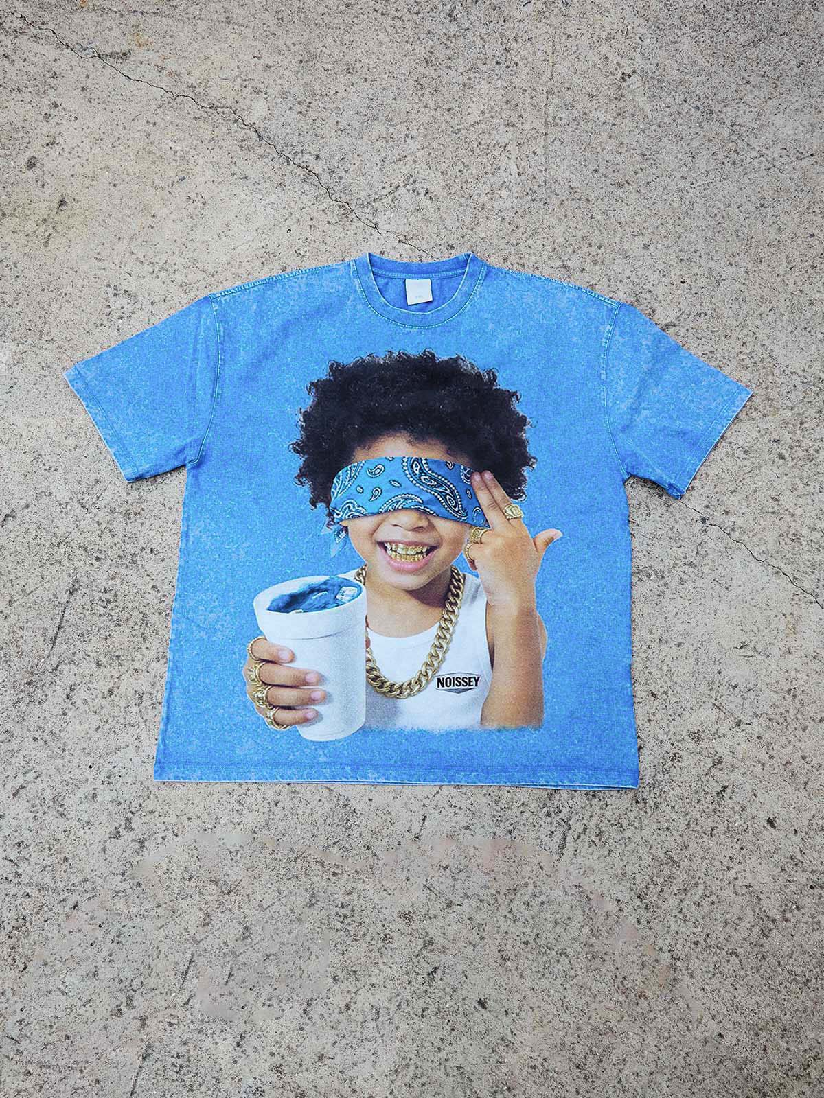 Flat lay of the distressed washed t-shirt with the unique blindfolded child and paisley print.