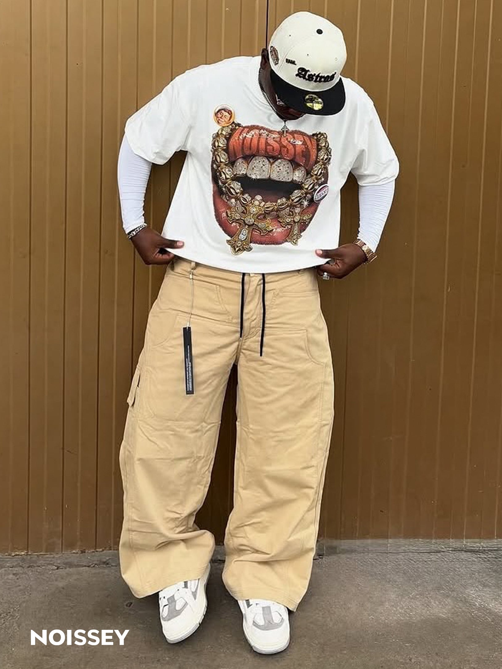 Male model wearing NOISSEY white boxy fit tee styled with brown cargo shorts
