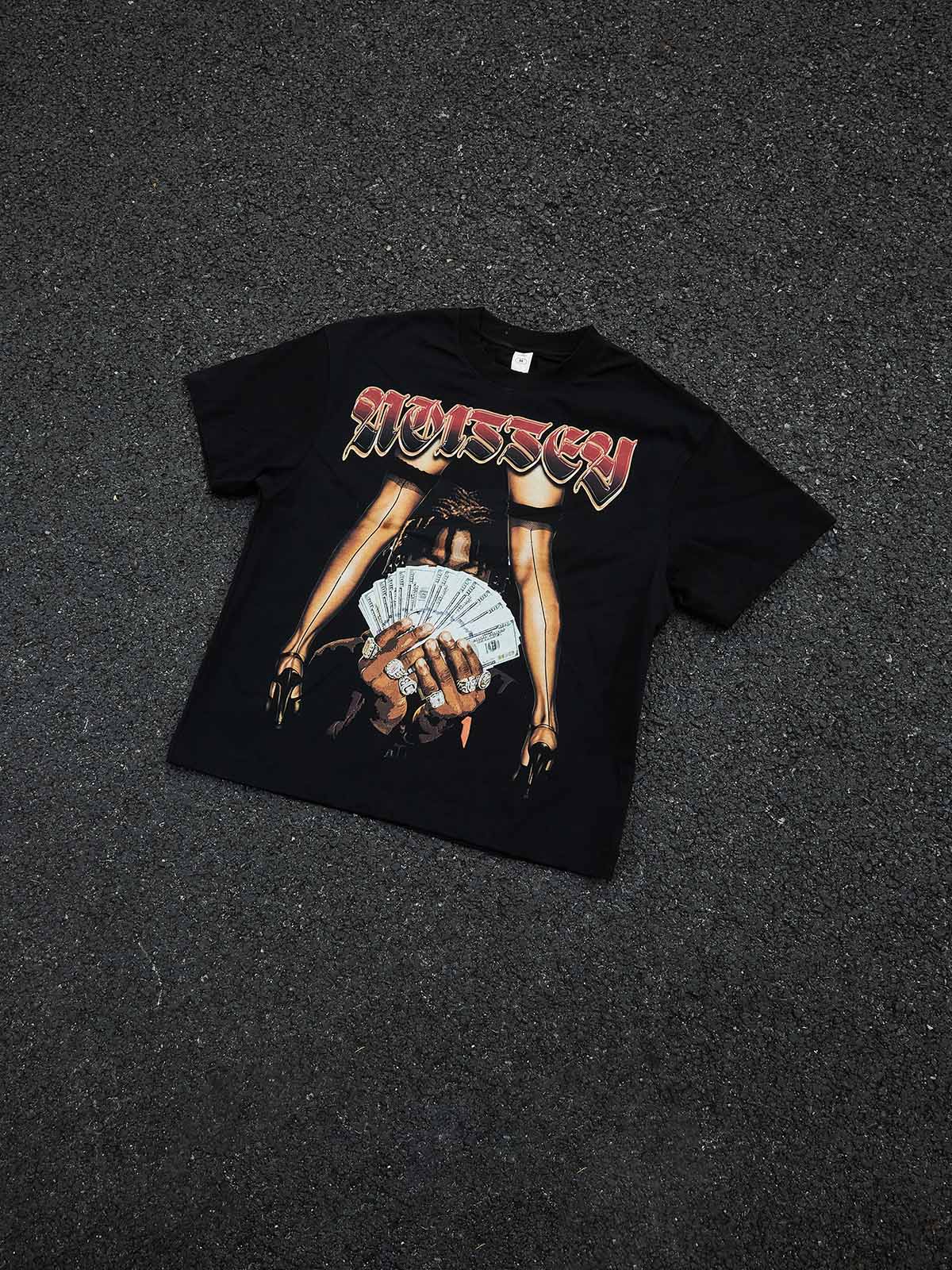 Professional flat lay of the black streetwear T-shirt on a white background, highlighting the vibrant red "Hustle" typography and glitter accents.