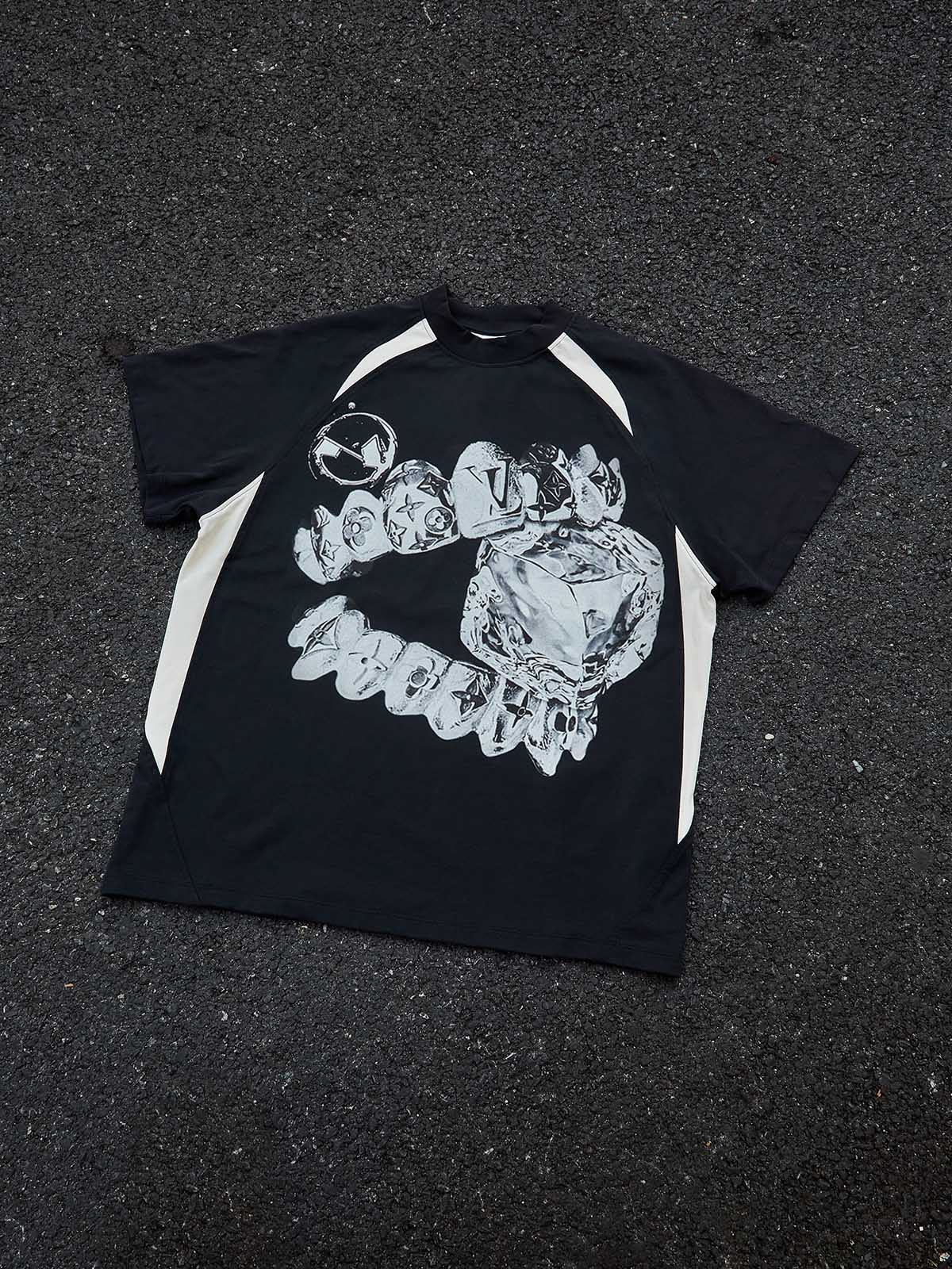 Studio flat lay of the Liquid Chrome Grillz tee showing the raglan sleeve construction and technical cooling print.