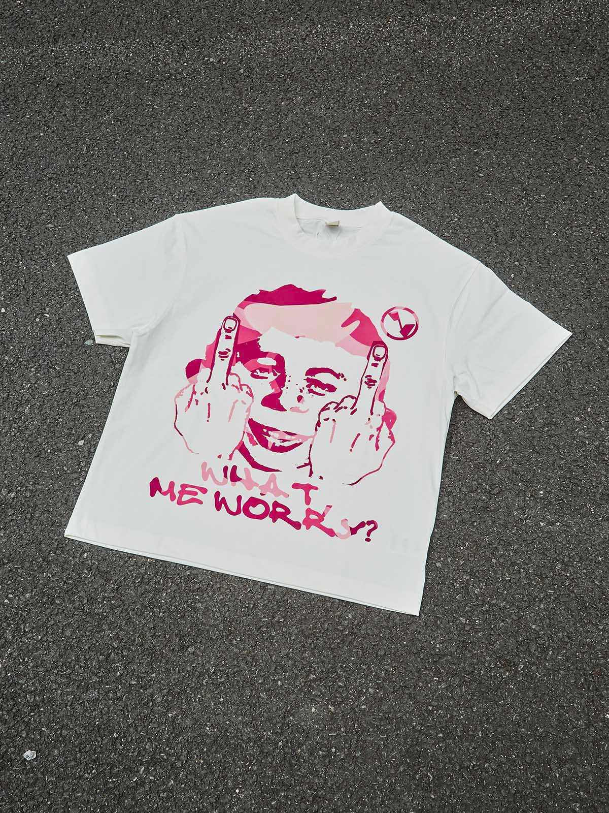 Top-down view of white graphic tee featuring a rebellious pink camo portrait and bold text on a neutral background.